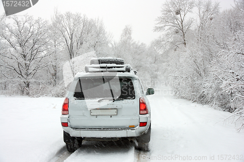 Image of Snowy winter road behind an unrecognizable car