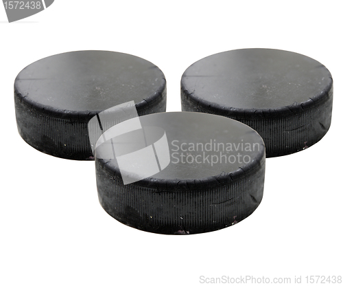 Image of Three old black hockey puck.