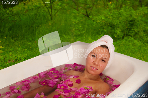 Image of beautiful woman enjoying floral bath