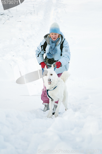 Image of The woman with a dog in winter on walk