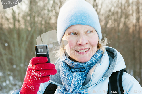 Image of The woman photographes on a mobile phone in winter on walk