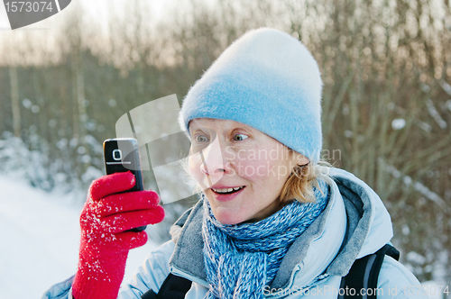 Image of The woman photographes on a mobile phone in winter on walk