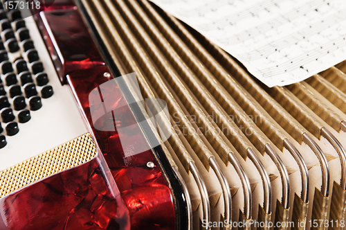 Image of Red accordion and sheet music, close up