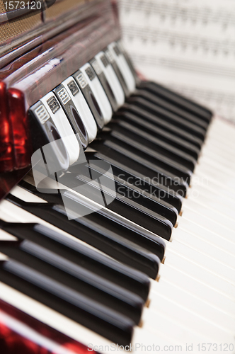 Image of Red accordion and sheet music, close up