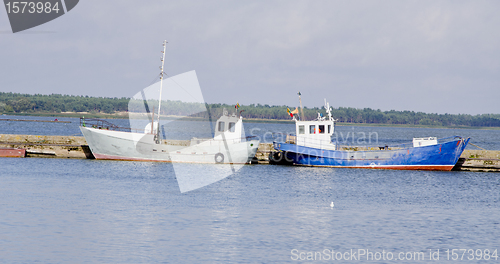 Image of boats water transport flags rest moored to dock 