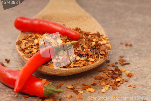 Image of Red chili peppers and red pepper flakes on a spoon