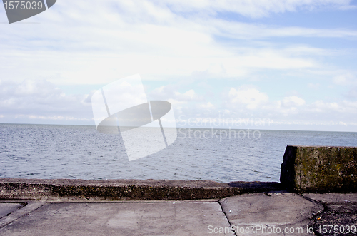 Image of Old concrete pier for ships and sea sky background 