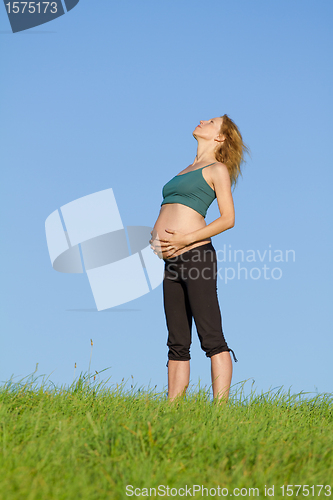 Image of pregnant woman on meadow