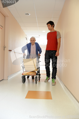 Image of male nurse and senior woman with walking frame