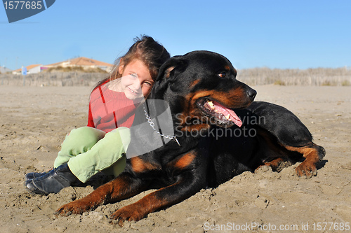 Image of rottweiler and child on the beach