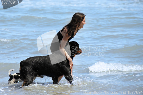 Image of rottweiler and girl in the sea
