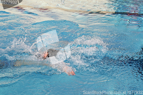 Image of young man swimming backstroke in water