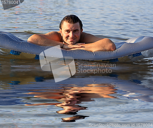 Image of man air mattress in the lake