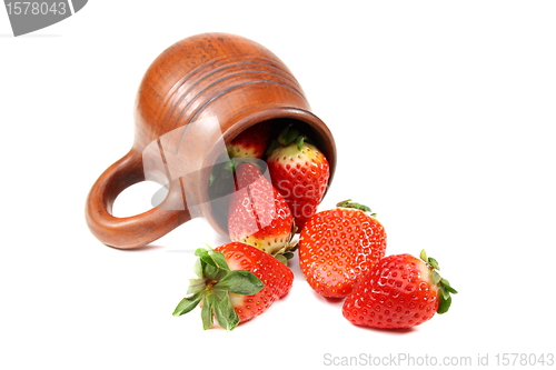 Image of Ripe strawberry and earthenware mug.