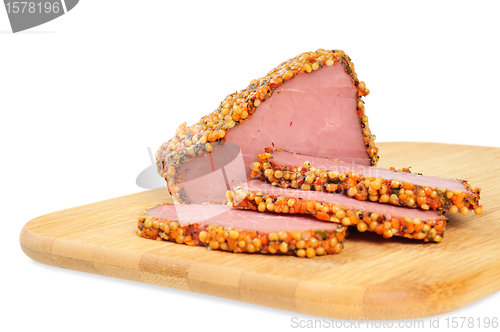 Image of Piece of a ham with spices on a wooden board
