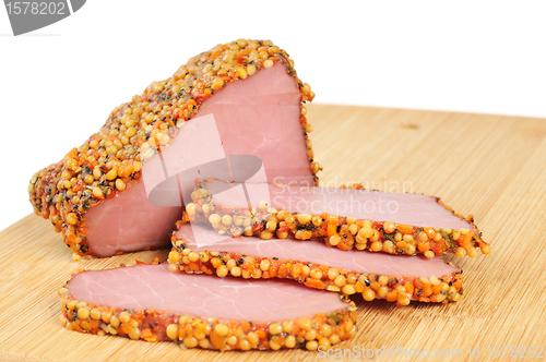 Image of Piece of a ham with spices on a wooden board