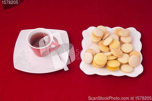 Image of Cup of tea and plate of mixed macaroons on a velvet tablecloth