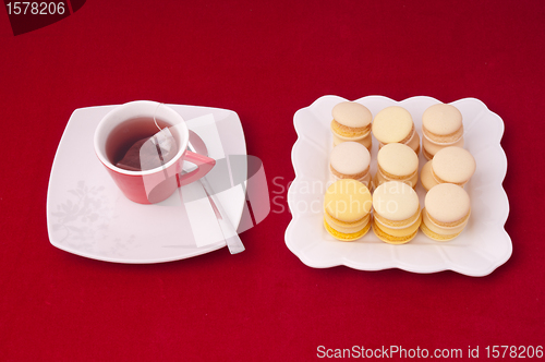 Image of Cup of tea and stacked and aligned macaroons on a velvet tablecl