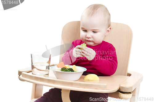 Image of young child eating in high chair