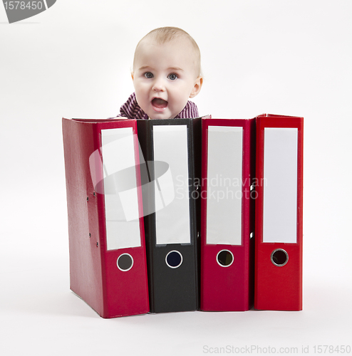 Image of young child hiding behind ring file