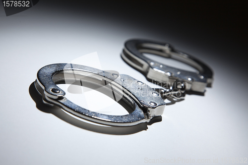 Image of Abstract Pair of Handcuffs Under Spot Light