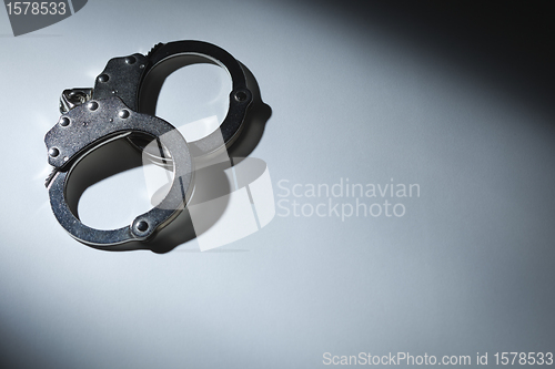 Image of Abstract Pair of Handcuffs Under Spot Light - Text Room
