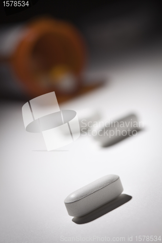 Image of Medicine Bottle and Pills Under Spot Light