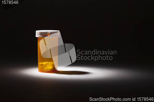 Image of Medicine Bottle and Pills Under Spot Light