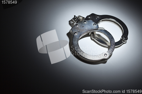 Image of Abstract Pair of Handcuffs Under Spot Light - Text Room