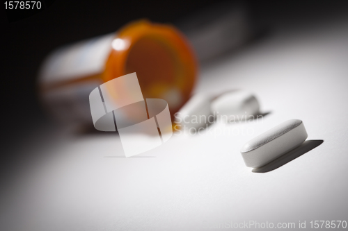 Image of Medicine Bottle and Pills Under Spot Light