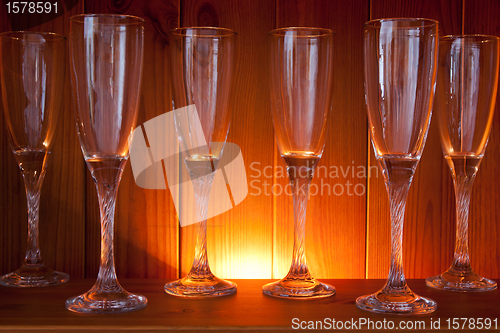 Image of Empty wine glasses on a wooden shelf