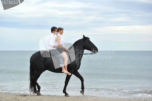 Image of couple and  horse on the beach