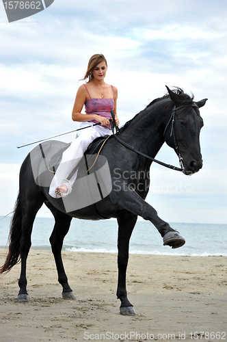 Image of girl and  horse on the beach