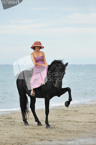 Image of girl and  horse on the beach