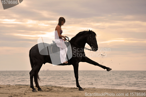 Image of girl and  horse on the beach