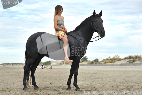 Image of woman and  horse on the beach