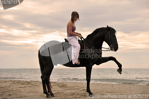 Image of girl and  horse on the beach