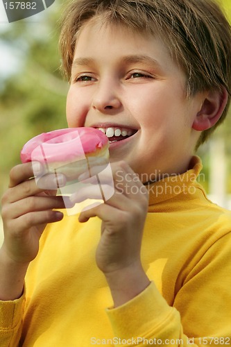 Image of Child eating a pink doughnut