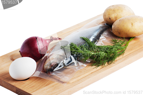 Image of Vegetables and a salty herring on a kitchen board