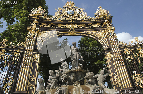 Image of fountain framed by a golden gate