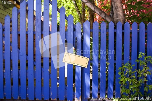 Image of Blue Fenced Door with a Blank Sign
