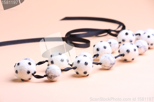 Image of White beads at pink background