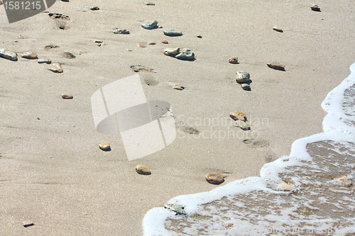 Image of Footprints at the beach among the stones