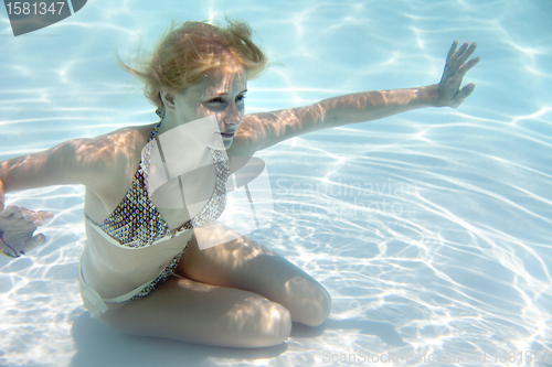 Image of Girl swimming underwater in a swimming pool 