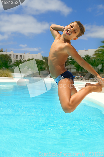 Image of boy jumping into the pool smiling 