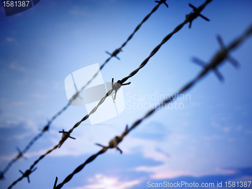 Image of barbed wire against evening sky 