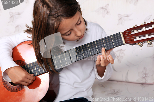 Image of Young girl play classical guitar