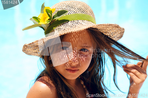 Image of Little girl wearing a hat near pool