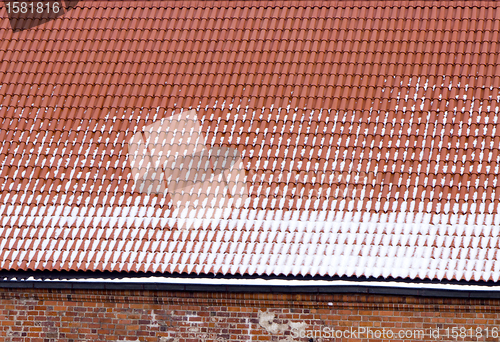 Image of snow clay tile roof red brick wall backdrop winter 