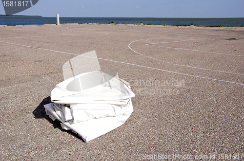 Image of Yacht fabric cover lying on concrete marina ground 